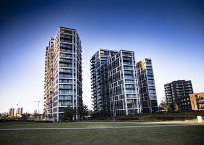 High-rise apartments nestled alongside a lush green park.
